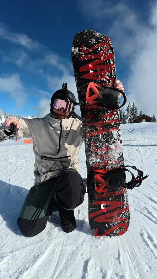 Bent Metal Anvil 2026-2027 On Snow Demo | Snowboarding Profiles Nate kneeling in the snow beside the bent metal anvil bindinigs